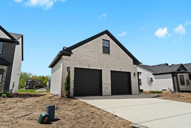 36135 Parkdale St Unit 5, Livonia, MI 48150 - view of side of home featuring brick siding, concrete driveway, and a garage