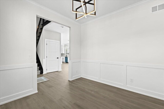 36135 Parkdale St Unit 5, Livonia, MI 48150 - empty room with stairway, a chandelier, dark wood-type flooring, crown molding, and wainscoting