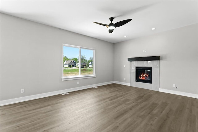 36135 Parkdale St Unit 5, Livonia, MI 48150 - unfurnished living room featuring wood finished floors, a tiled fireplace, a ceiling fan, baseboards, and recessed lighting