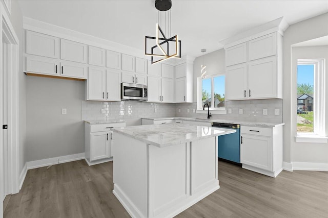 36135 Parkdale St Unit 5, Livonia, MI 48150 - kitchen with dishwashing machine, stainless steel microwave, a sink, and wood finished floors