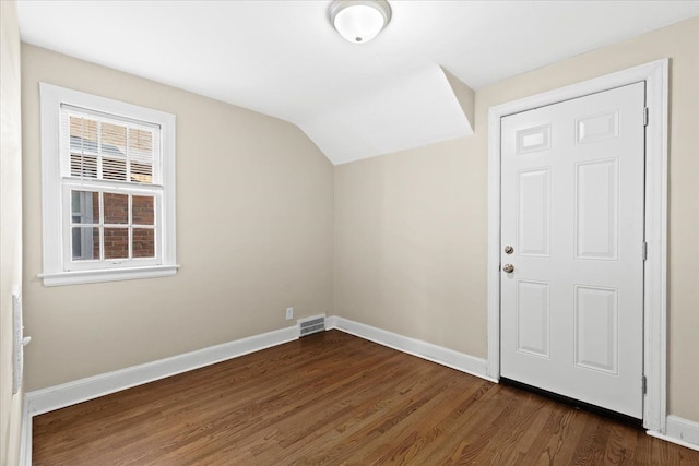 entrance foyer with dark hardwood / wood-style floors and lofted ceiling