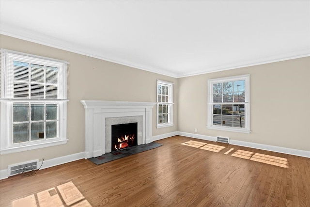 unfurnished living room featuring hardwood / wood-style floors, crown molding, and a tile fireplace