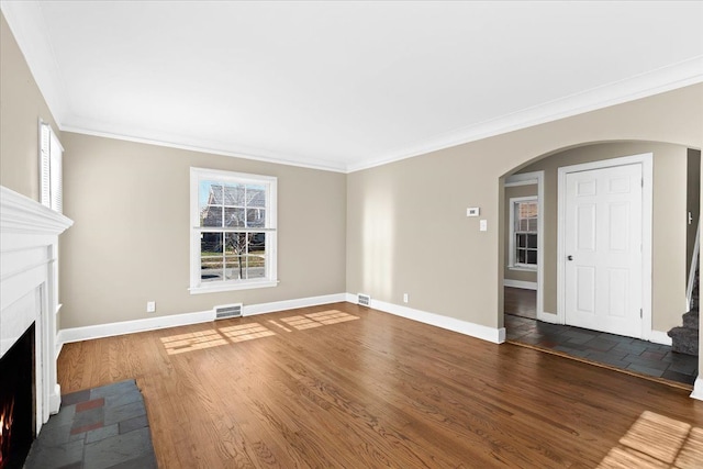 unfurnished living room featuring plenty of natural light, dark hardwood / wood-style floors, and crown molding