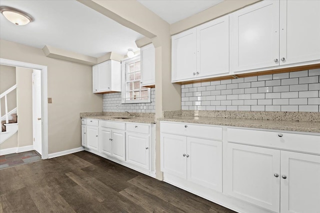 kitchen featuring tasteful backsplash, white cabinetry, and sink