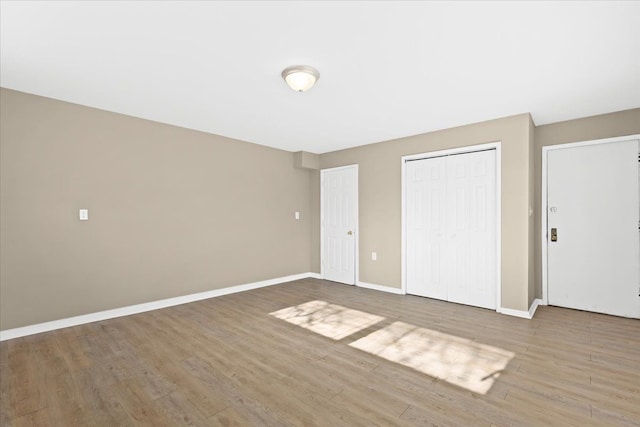 unfurnished bedroom featuring wood-type flooring and a closet