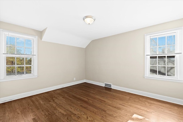 bonus room with hardwood / wood-style floors and vaulted ceiling