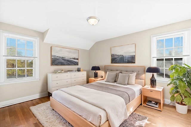 bedroom featuring lofted ceiling and light wood-type flooring