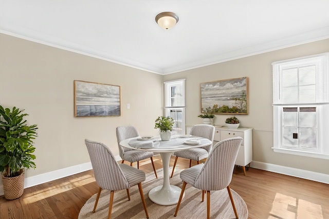 dining area with light hardwood / wood-style flooring and crown molding