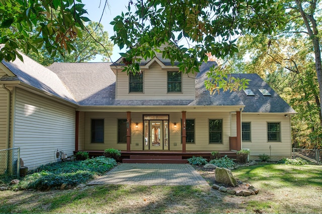 back of property featuring a porch and a lawn