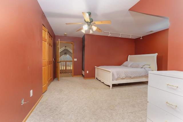 bedroom with light colored carpet, track lighting, and ceiling fan