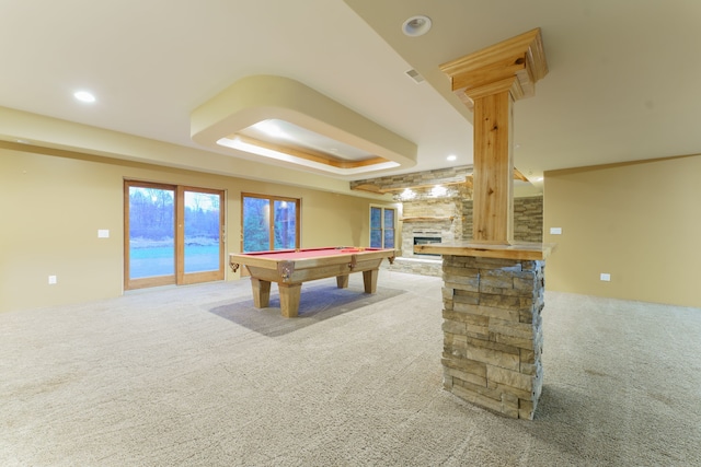 rec room featuring a tray ceiling, a stone fireplace, carpet, and pool table