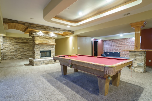 playroom featuring carpet flooring, ornate columns, a raised ceiling, billiards, and a stone fireplace