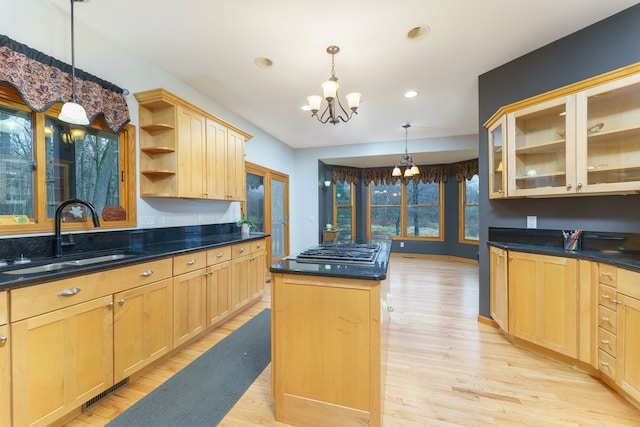 kitchen featuring a chandelier, light brown cabinets, a center island, and sink