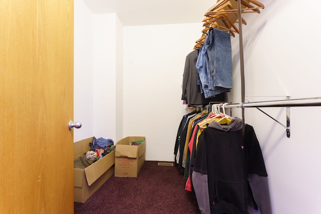 walk in closet featuring dark carpet