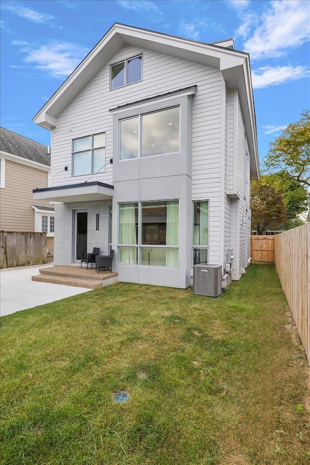 back of house featuring a lawn, central air condition unit, and a patio