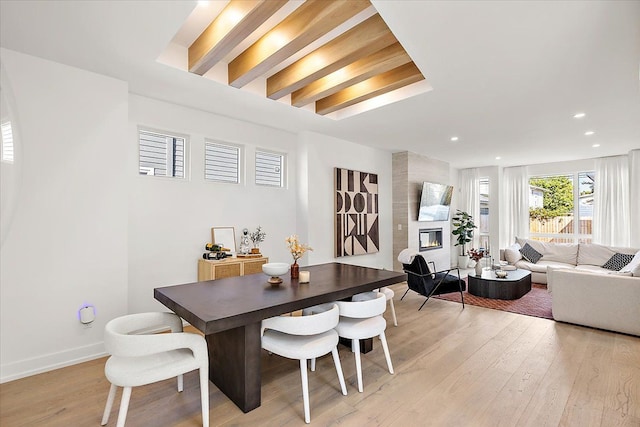 dining area with a fireplace and light hardwood / wood-style flooring