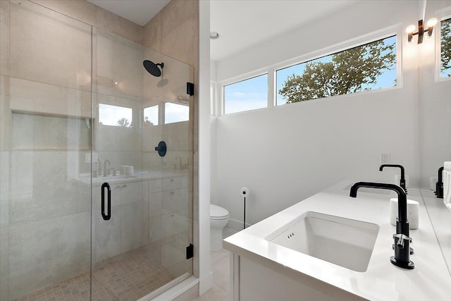 bathroom with plenty of natural light, tile patterned flooring, a shower with door, and toilet