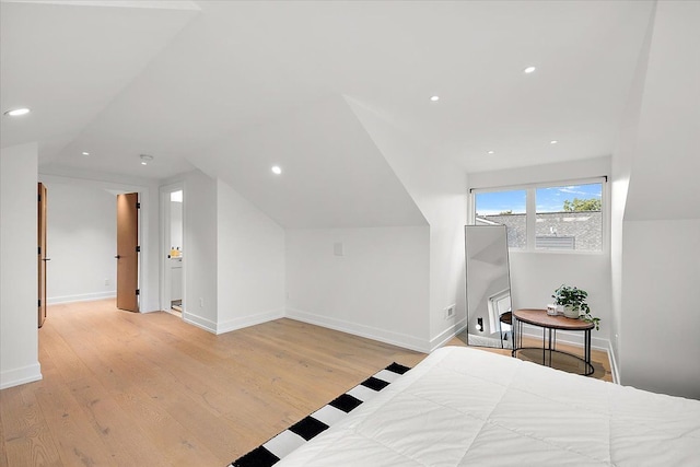 bedroom with light hardwood / wood-style floors and lofted ceiling