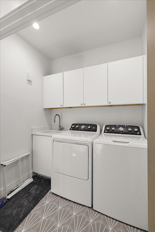 laundry area featuring cabinets, separate washer and dryer, and sink