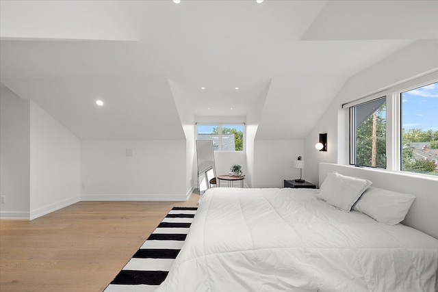 bedroom with multiple windows, light hardwood / wood-style flooring, and vaulted ceiling