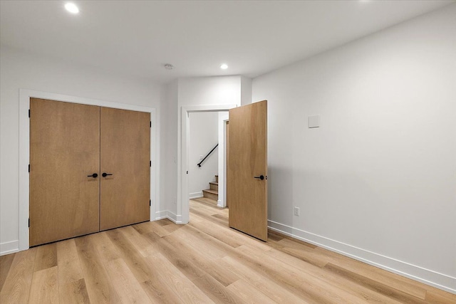 unfurnished bedroom featuring light hardwood / wood-style floors and a closet