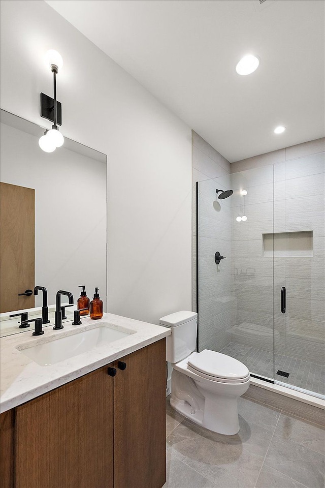 bathroom with tile patterned flooring, vanity, toilet, and an enclosed shower