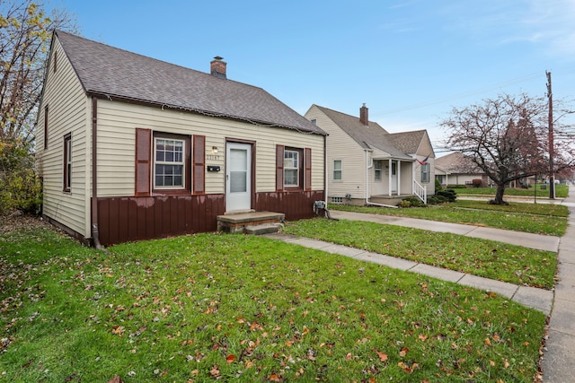 22167 Rausch Ave, Eastpointe, MI 48021 - view of front of home with a front lawn, a chimney, and roof with shingles