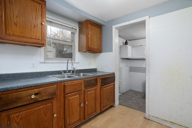 22167 Rausch Ave, Eastpointe, MI 48021 - kitchen with a sink, dark countertops, light wood-style floors, and brown cabinets