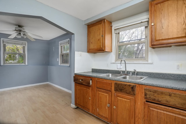 22167 Rausch Ave, Eastpointe, MI 48021 - kitchen featuring a sink, dark countertops, brown cabinetry, and light wood finished floors