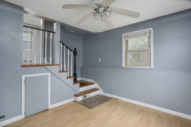 staircase featuring hardwood / wood-style flooring and ceiling fan