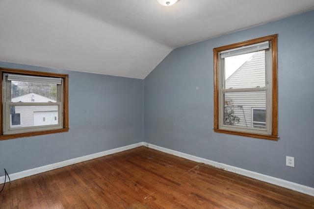 bonus room with a healthy amount of sunlight, dark wood-type flooring, and vaulted ceiling