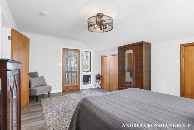 1155 Edgewater Ter, South Haven, MI 49090 - bedroom featuring wood finished floors, lofted ceiling, baseboards, and access to exterior