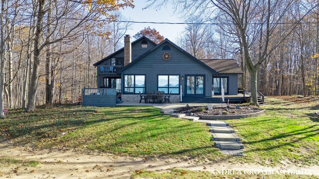 1155 Edgewater Ter, South Haven, MI 49090 - rustic home with a chimney, a front yard, a deck, and a patio area