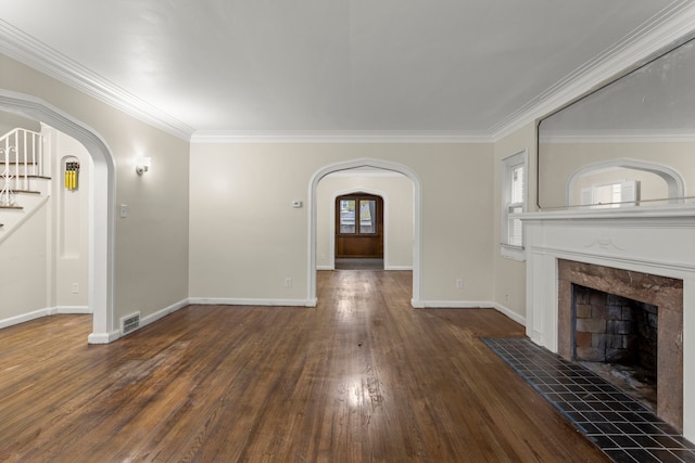 unfurnished living room featuring dark hardwood / wood-style floors, ornamental molding, and a tile fireplace