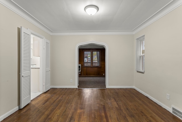 spare room with dark hardwood / wood-style flooring, crown molding, and plenty of natural light