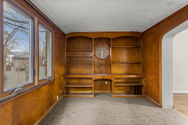 unfurnished office featuring carpet floors, a textured ceiling, and ornamental molding