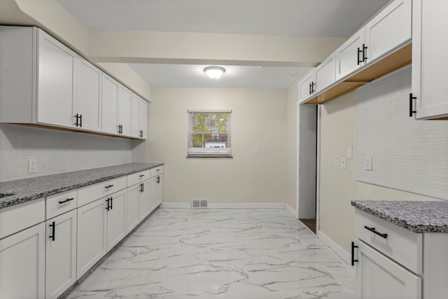 kitchen with white cabinets and light stone counters