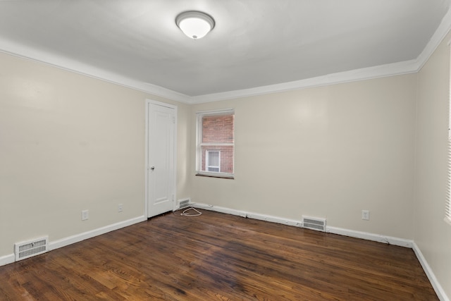 empty room featuring dark hardwood / wood-style flooring and ornamental molding