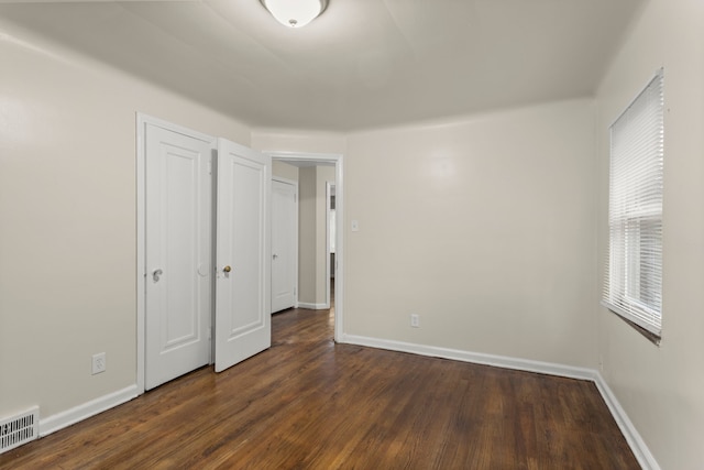 unfurnished bedroom with dark hardwood / wood-style flooring