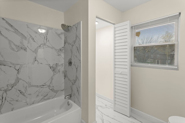 bathroom with tiled shower / bath combo and toilet