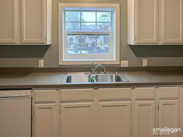 kitchen with dishwasher, white cabinetry, and sink