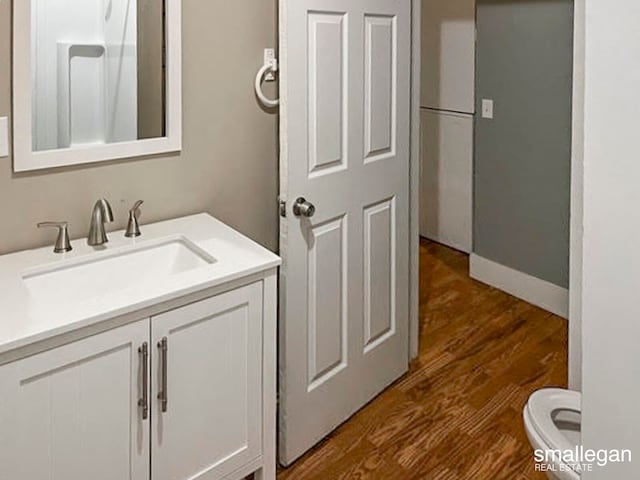 bathroom featuring vanity, hardwood / wood-style flooring, and toilet