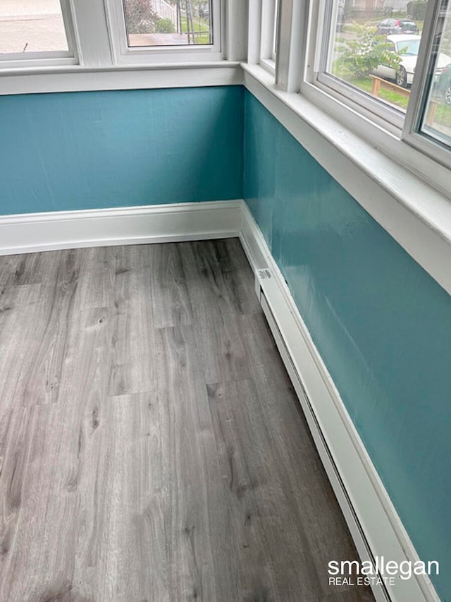 interior details with hardwood / wood-style floors and baseboard heating