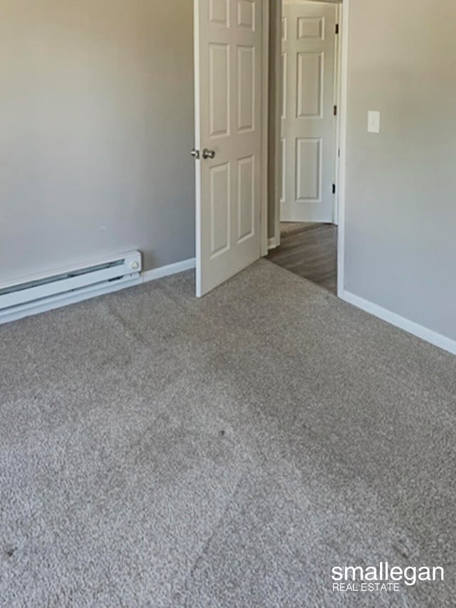 unfurnished room featuring a baseboard radiator and dark carpet