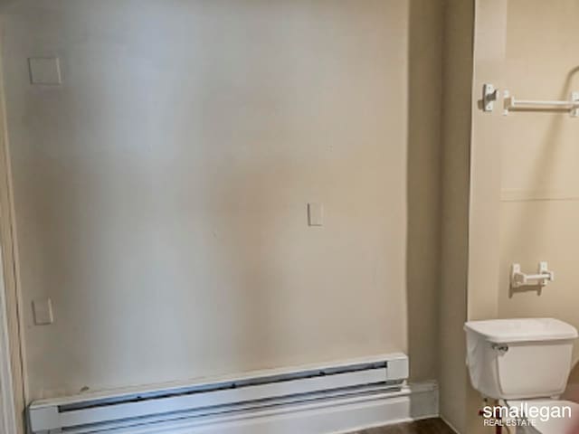 bathroom featuring hardwood / wood-style flooring, toilet, and baseboard heating