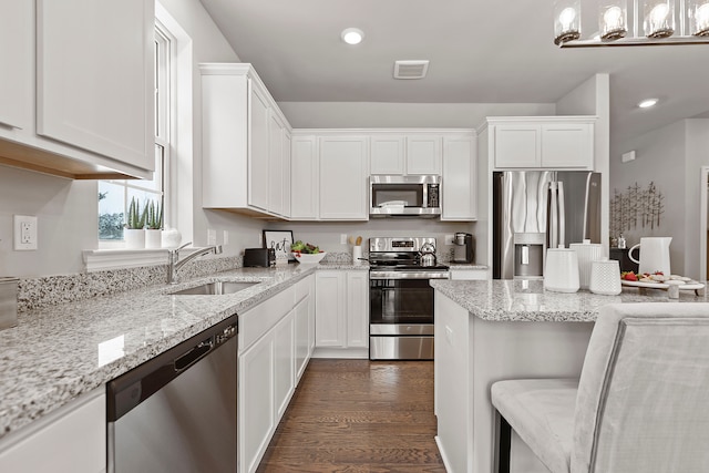 kitchen featuring stainless steel appliances, white cabinetry, dark wood-type flooring, and sink