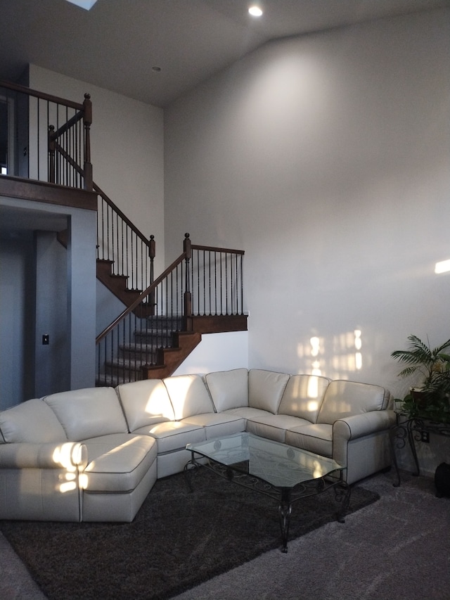 living room with carpet floors and high vaulted ceiling