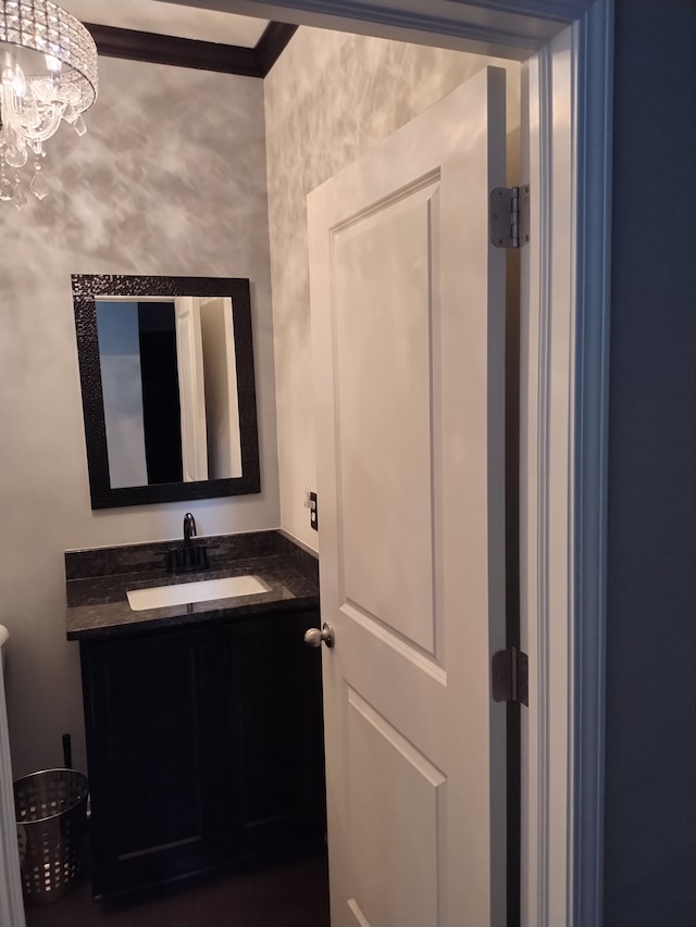 bathroom with vanity, an inviting chandelier, and crown molding