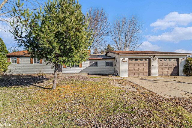 470 Michelson Rd, Houghton Lake, MI 48629 - view of grassy yard featuring a garage and concrete driveway