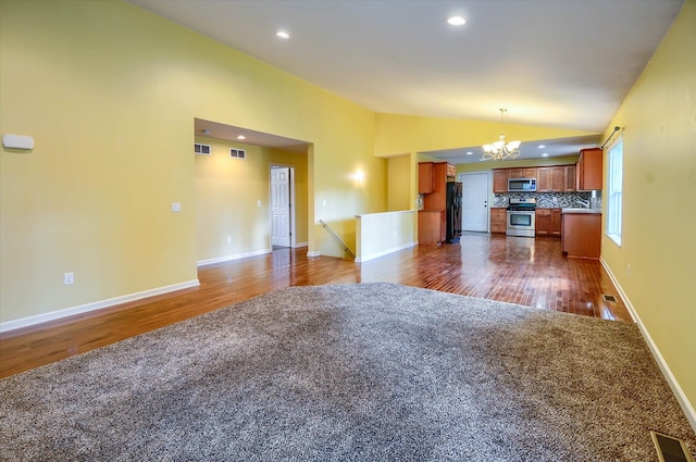 unfurnished living room featuring a notable chandelier, dark hardwood / wood-style flooring, and lofted ceiling